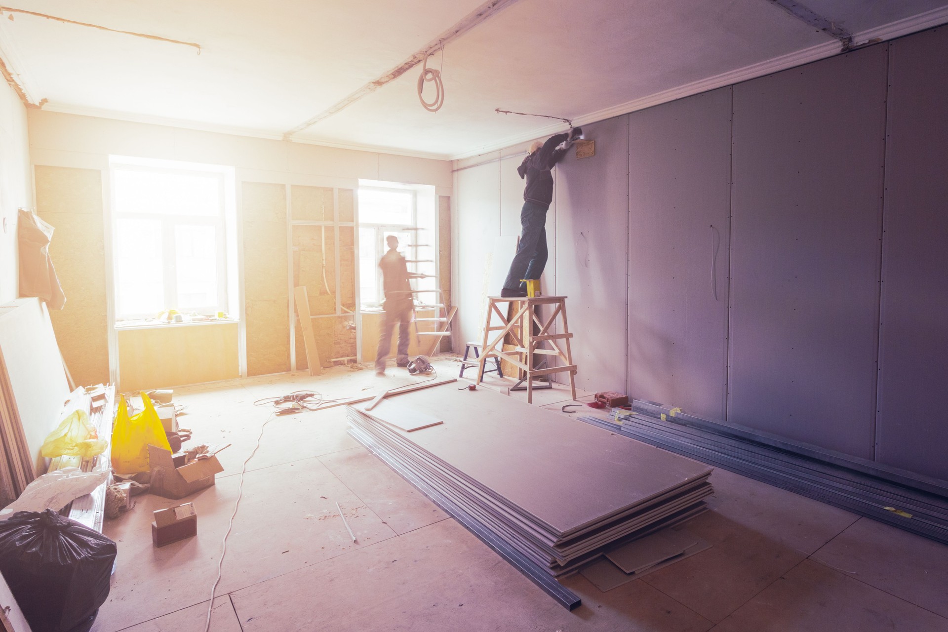 Los trabajadores a instalar placas de yeso (drywall) para paredes de yeso en apartamento está en construcción, remodelación, restauración, ampliación, restauración y reconstrucción.