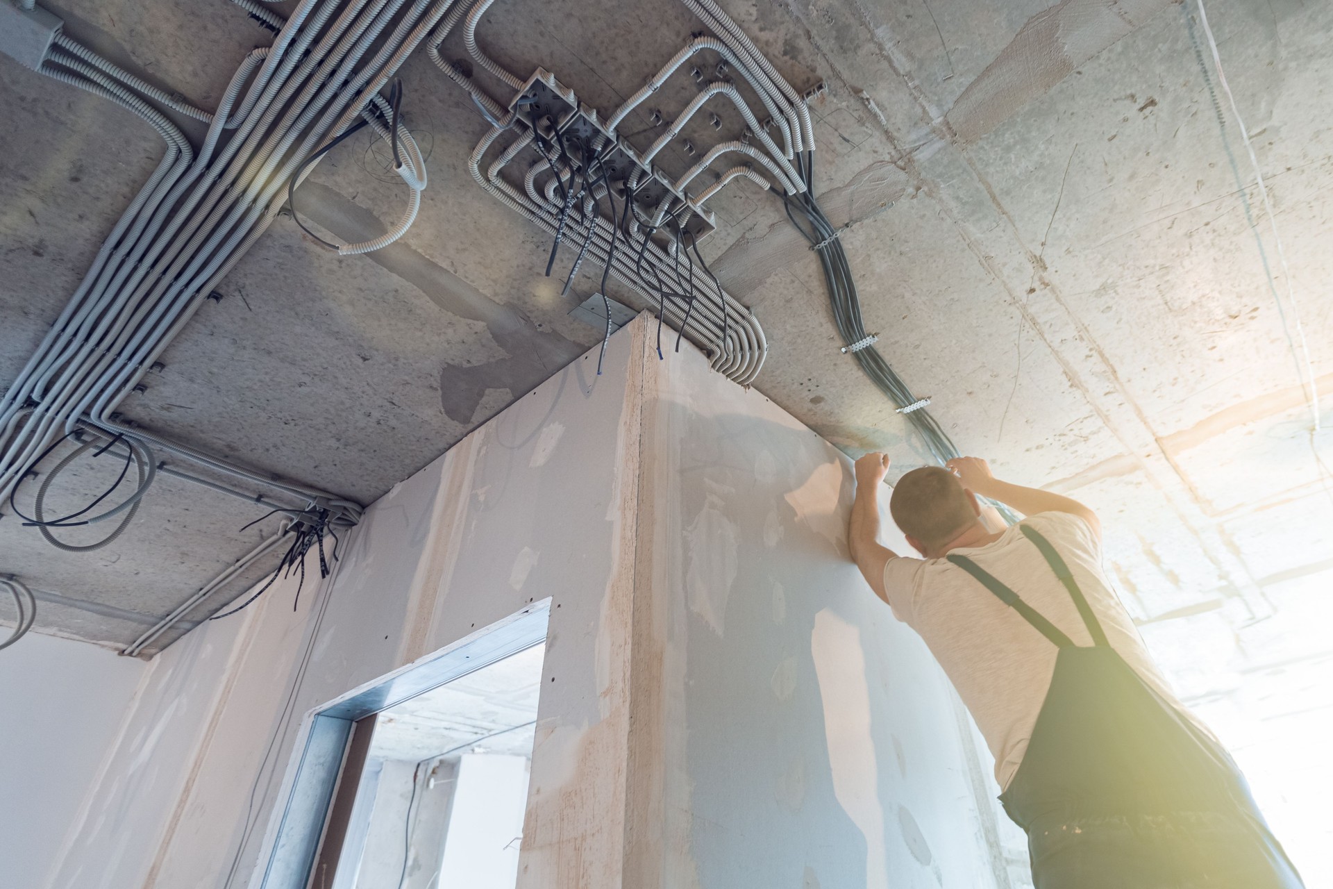 El trabajador está instalando los cables eléctricos en el techo que es la parte del cableado interno en el apartamento está en construcción, remodelación, renovación, extensión, restauración y reconstrucción. Concepto de casa inteligente.